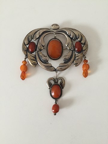 Art Nouveau unika broche fra 1910-1920 med ravsten. Ukendt kunstnermonogram. 
